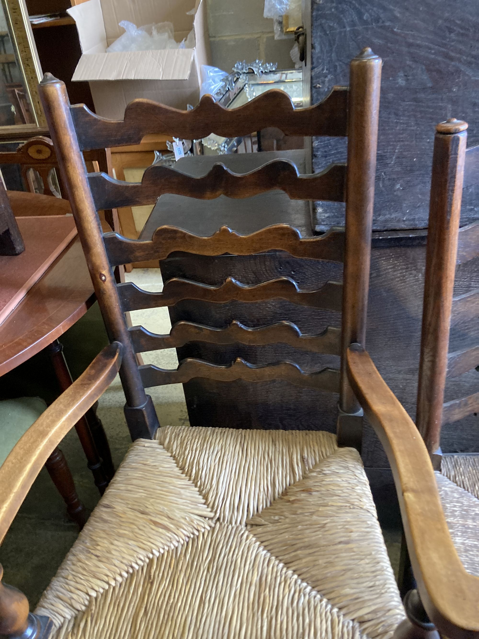 A harlequin set of seven oak and beech rush seated, ladder back dining chairs